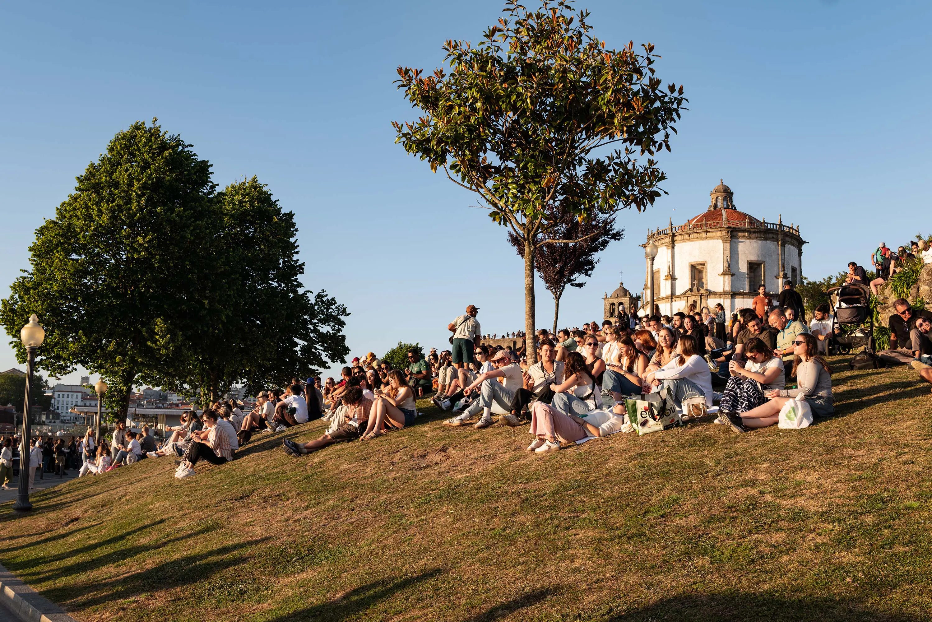 Menschen genießen den Sonnenuntergang in Vila Nova de Gaia mit Blick auf Porto